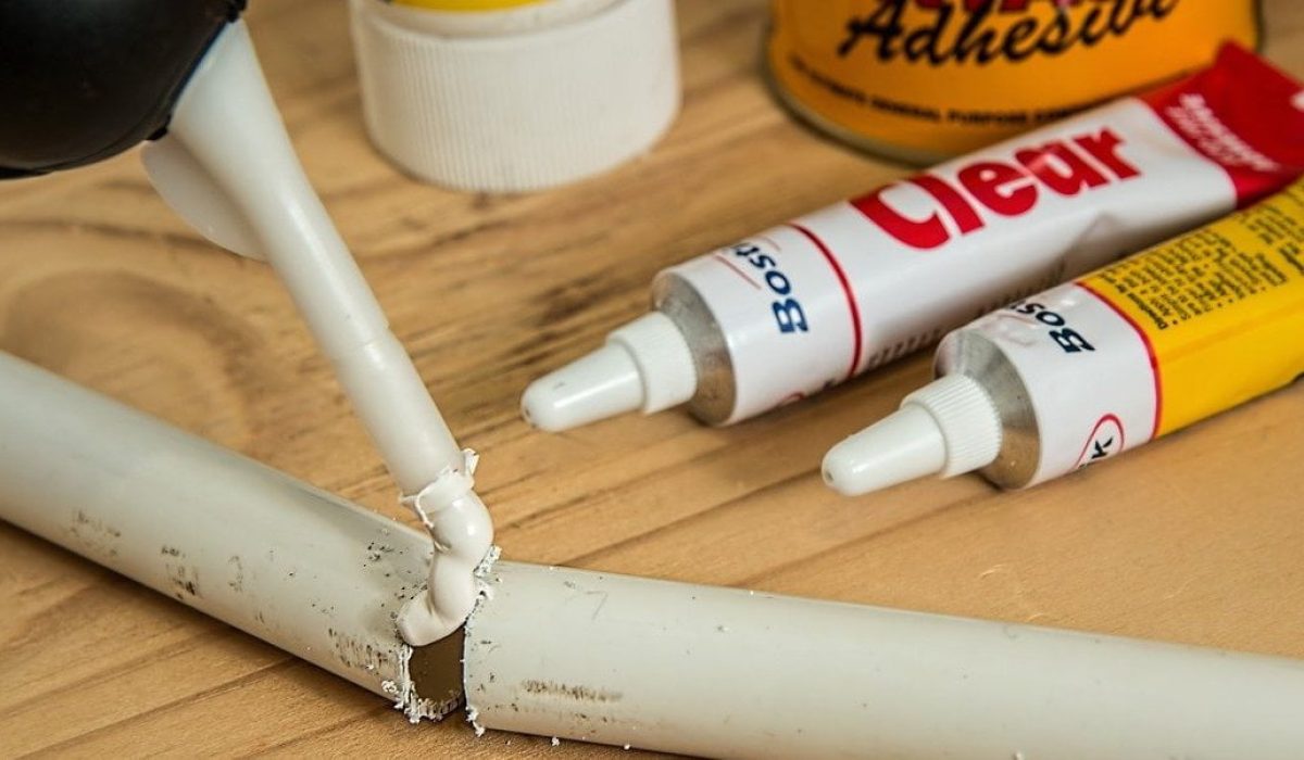 Pipework being repaired by glue on a wooden table